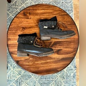 Black lace up boots with brown heel, and sweater-knit ankle cuff